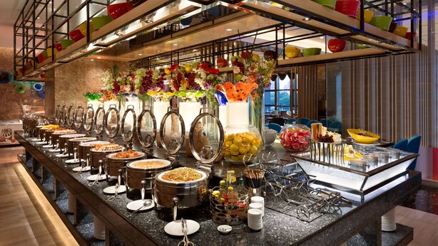 A buffet setup with various food items and utensils. - Ramada Foshan Nanhai (Foshan)