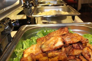 A buffet with various food options, including fried chicken and other dishes. - Soluxe Hotel Almaty (Almaty)