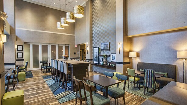 A hotel lobby with a bar area, seating arrangements, and a check-in counter. - Hampton Inn Hibbing (Hibbing)