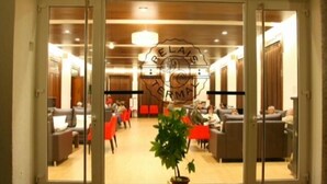 A hotel lobby with a reception desk, seating area, and a potted plant. - Balneario Acuña (Caldas de Reis)