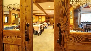 Un restaurante con decoración de madera y mesas dispuestas para comer.