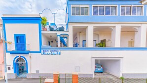 A hotel with a blue and white facade, a balcony with a railing, and a sign that reads "Hotel Celeste". - Hotel Celeste (Procida)