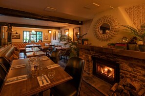 A cozy restaurant with a stone fireplace, wooden tables, and comfortable seating. - Ring O Bells (Bristol)