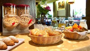 Ein reichhaltiges Frühstücksbuffet mit verschiedenen Brotsorten, Gebäck und Früchten.