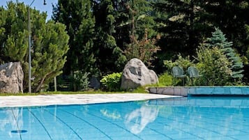 Una piscina al aire libre de temporada, sillones reclinables de piscina