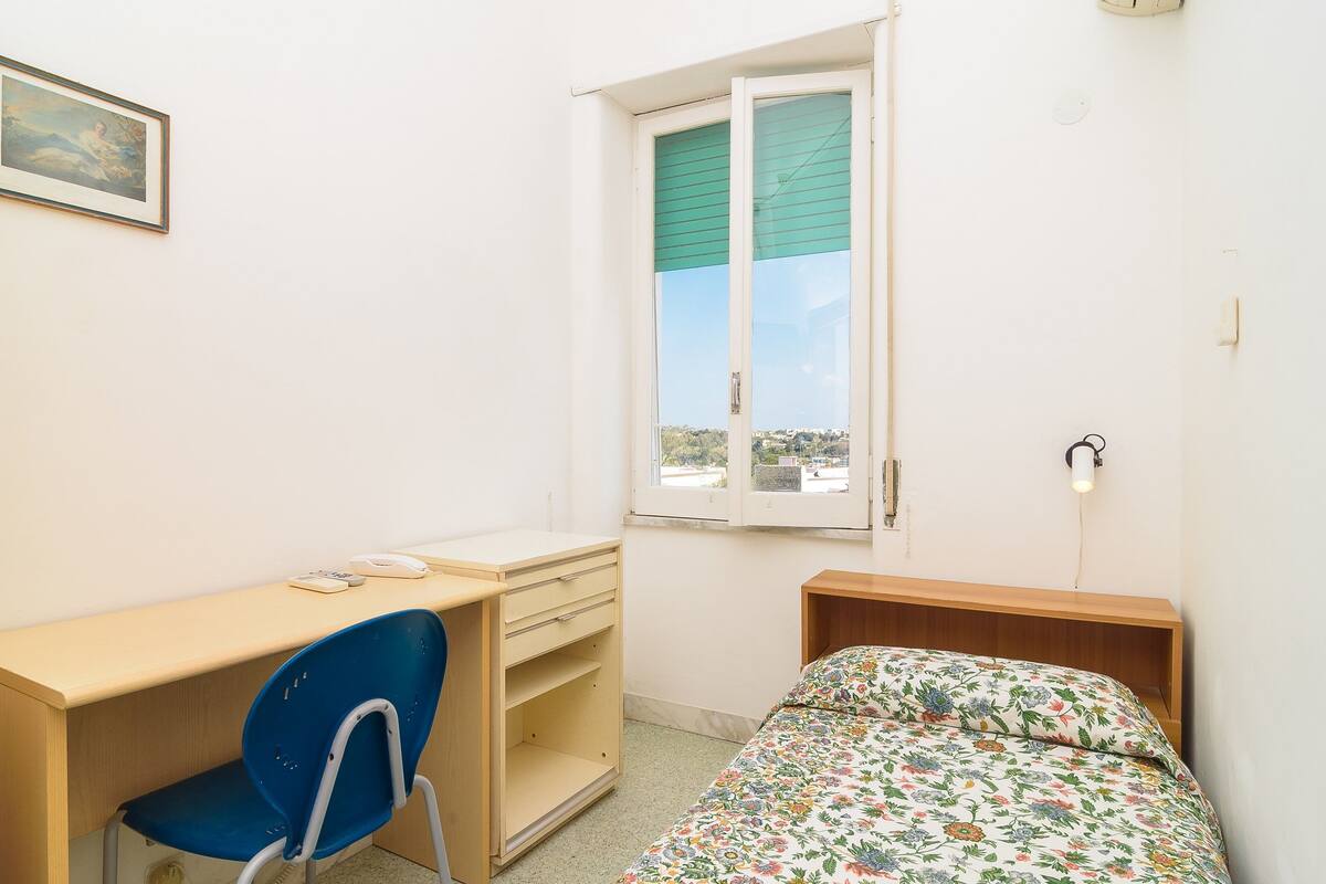 Ein Schlafzimmer mit einem Bett, einem Schreibtisch und einem Stuhl.