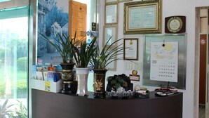 Una recepción con diplomas enmarcados, un reloj de pared y un calendario.