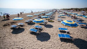 A beach with rows of sunbeds and umbrellas. - Campingvillaggio Atlanta e Mediterraneo - Campground (Chioggia)