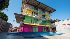 Un edificio de varios pisos con balcones y una piscina delantera.