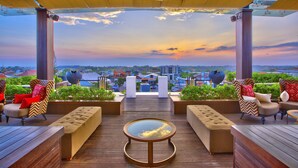 Un área de estar al aire libre con vistas a la ciudad al atardecer.