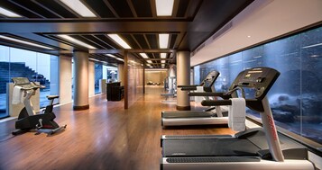 Ett modernt gym med flera löpband, motionscyklar och en crosstrainer.
