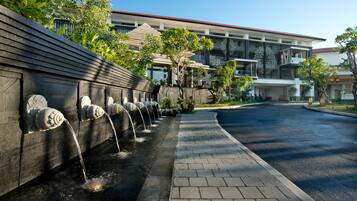 A modern building with a water feature along a paved walkway.