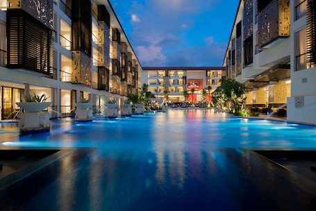 Una piscina al aire libre, sombrillas, sillones reclinables de piscina