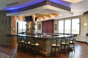A modern bar area with a central island, bar stools, and a well-stocked bar counter. - Hotel Plaza Juan Carlos (Tegucigalpa)