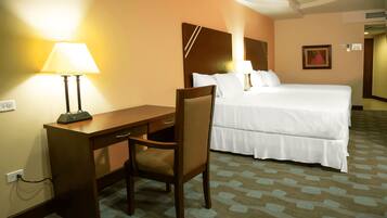 Ein Hotelzimmer mit Bett, Schreibtisch, Stuhl und Lampe.
