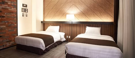 A hotel room with two beds, a brick wall, wooden paneling, and a ceiling light.