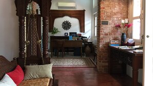 Una habitación tradicional con una cama de madera, un escritorio y una pared de ladrillo.