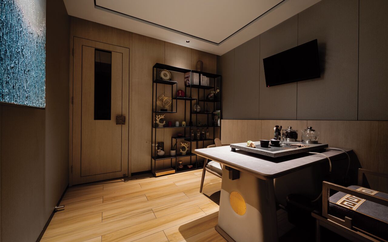 A modern kitchen with a wooden floor, a built-in island, and a wall-mounted TV.