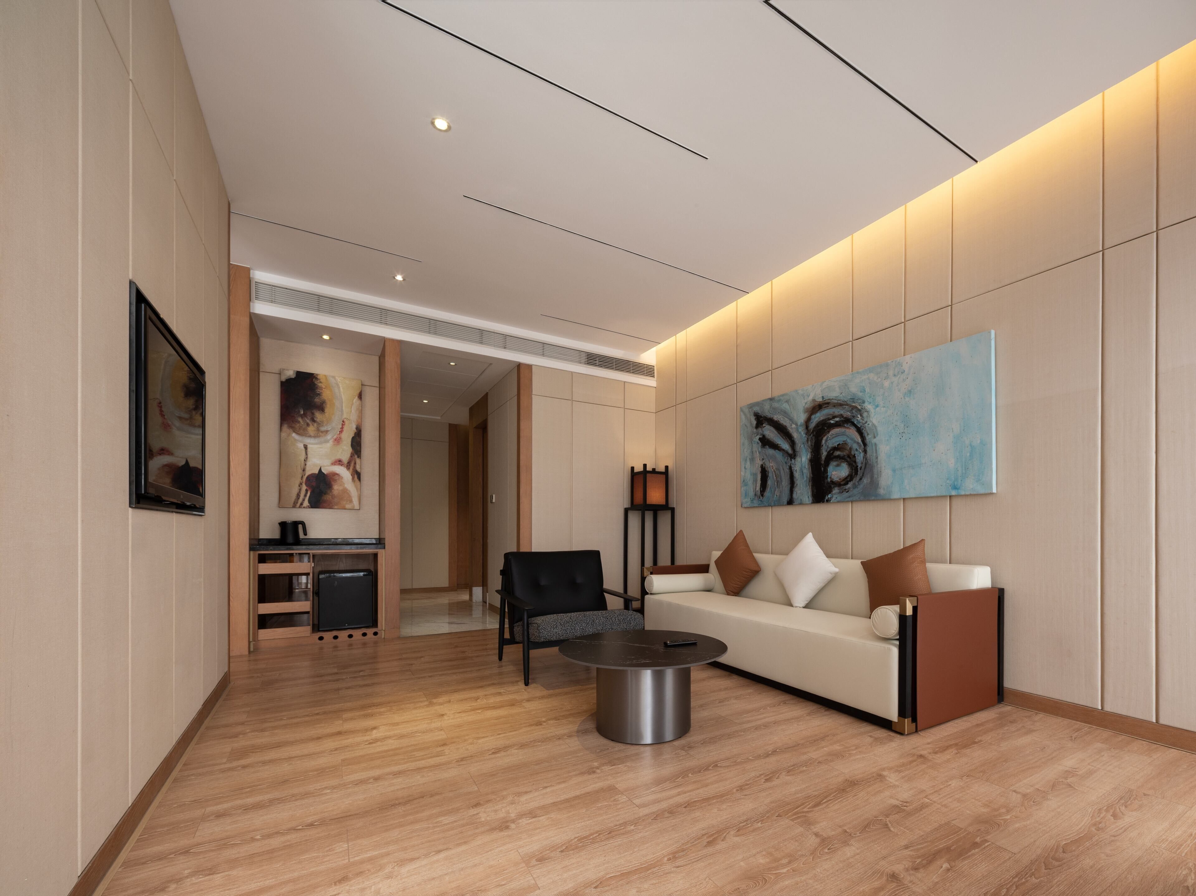 A modern living room with a sofa, coffee table, and artwork on the wall.