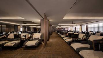 A hotel room with multiple beds arranged in rows, a carpeted floor, and ceiling fans.