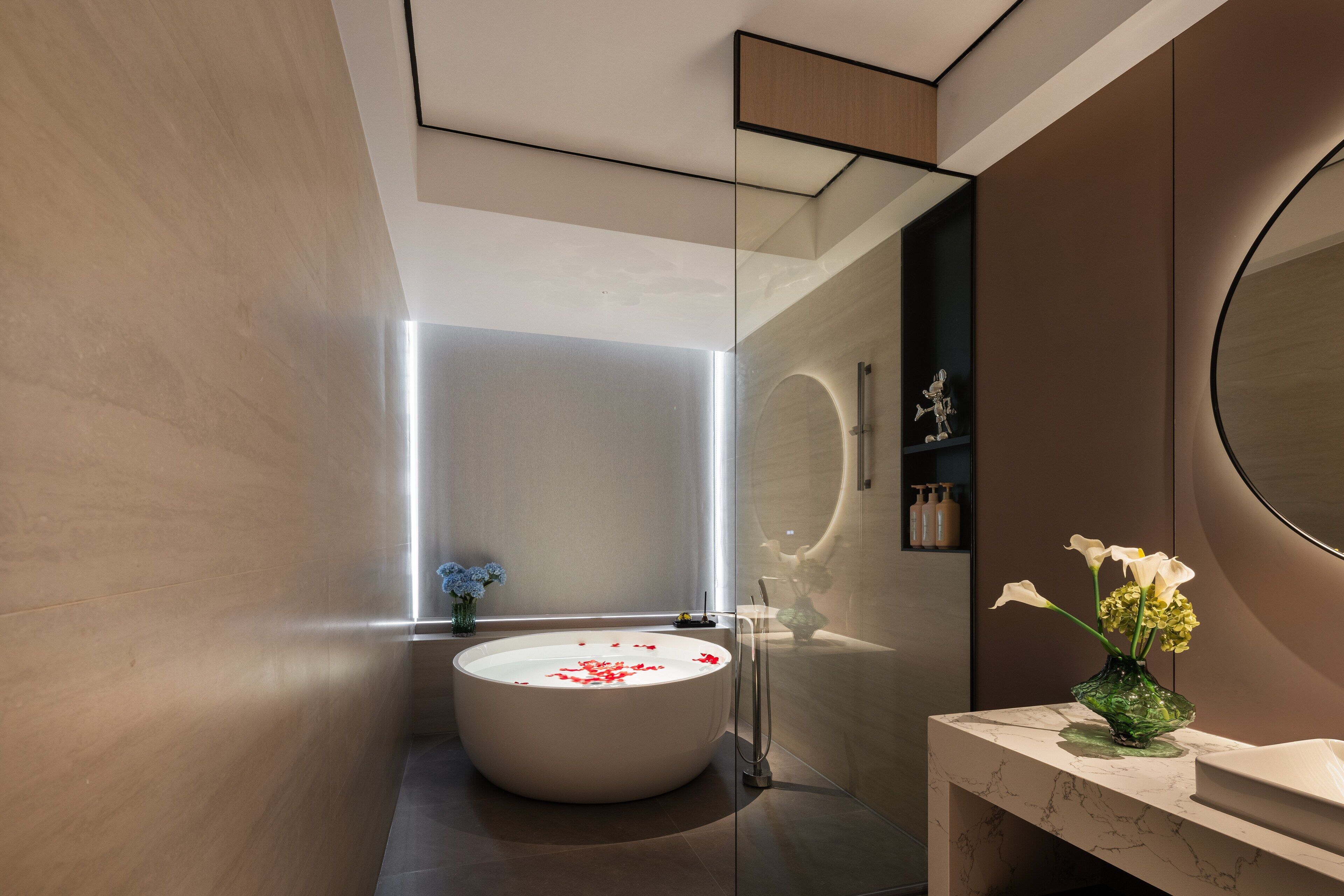 A modern bathroom with a freestanding bathtub, a marble countertop, and a large mirror.
