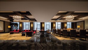 A spacious hotel lobby with a red sofa set, a dining area, and large chandeliers. - Palm Spring Hotel (Zhuhai)