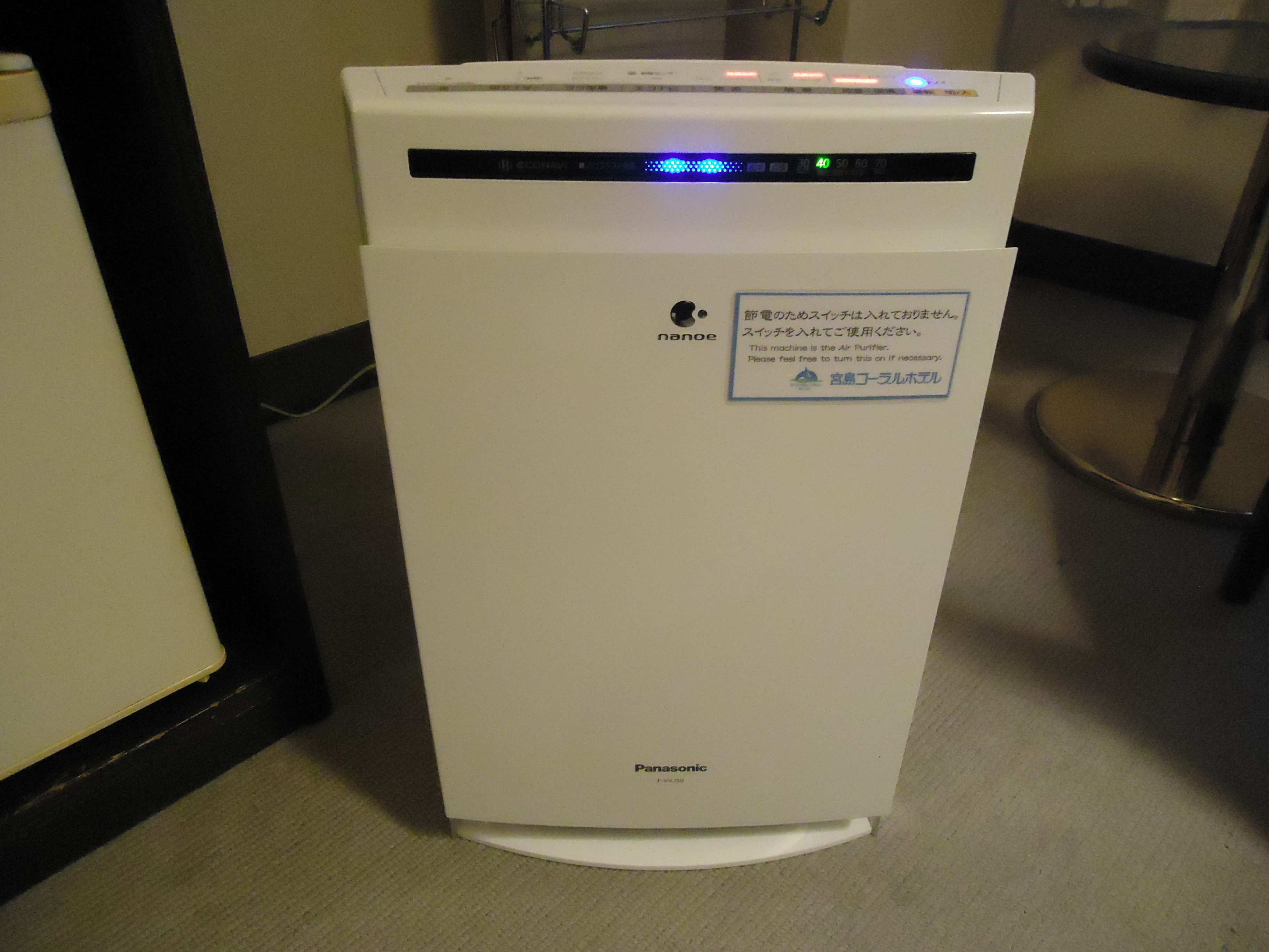 A white Panasonic air purifier with a digital display and a blue light indicator.