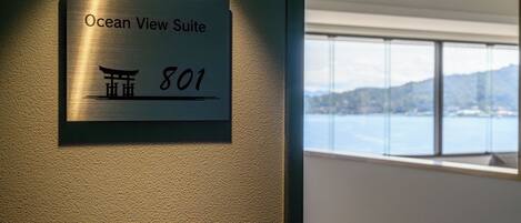 A sign for the Ocean View Suite, number 801, with a view of a building and mountains in the background.