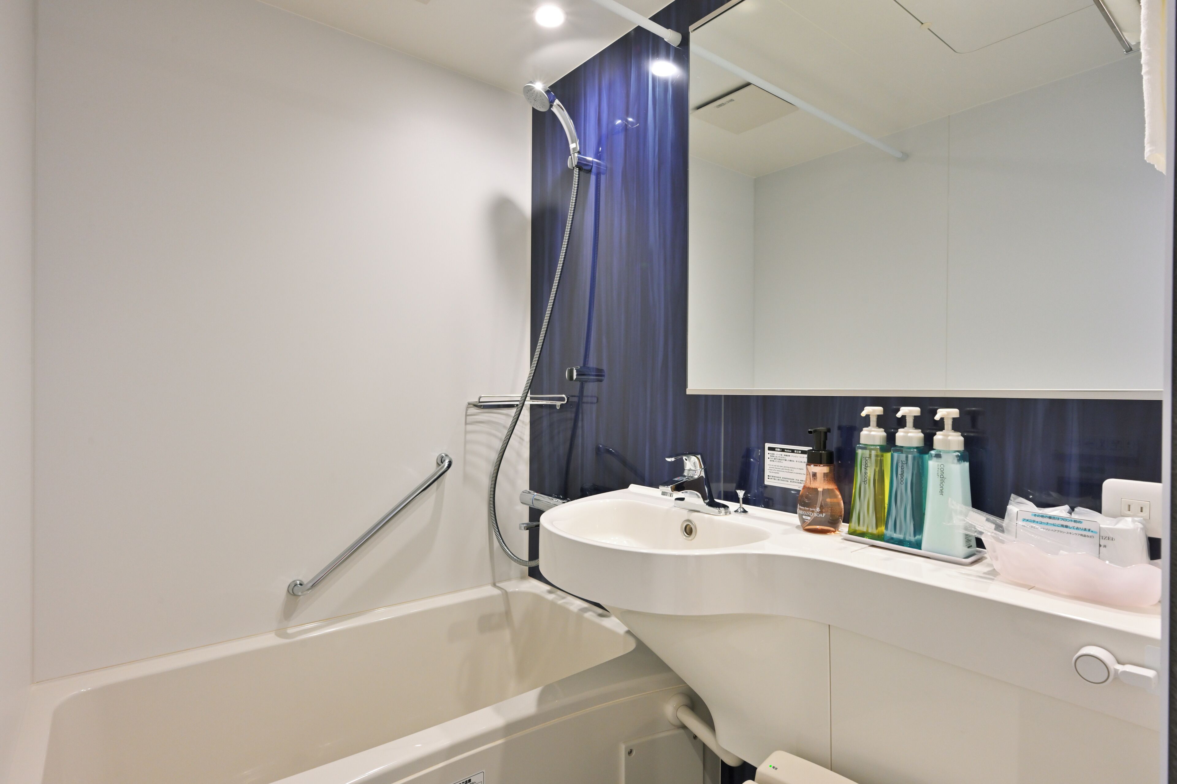 A modern bathroom with a bathtub, a sink, and a mirror.
