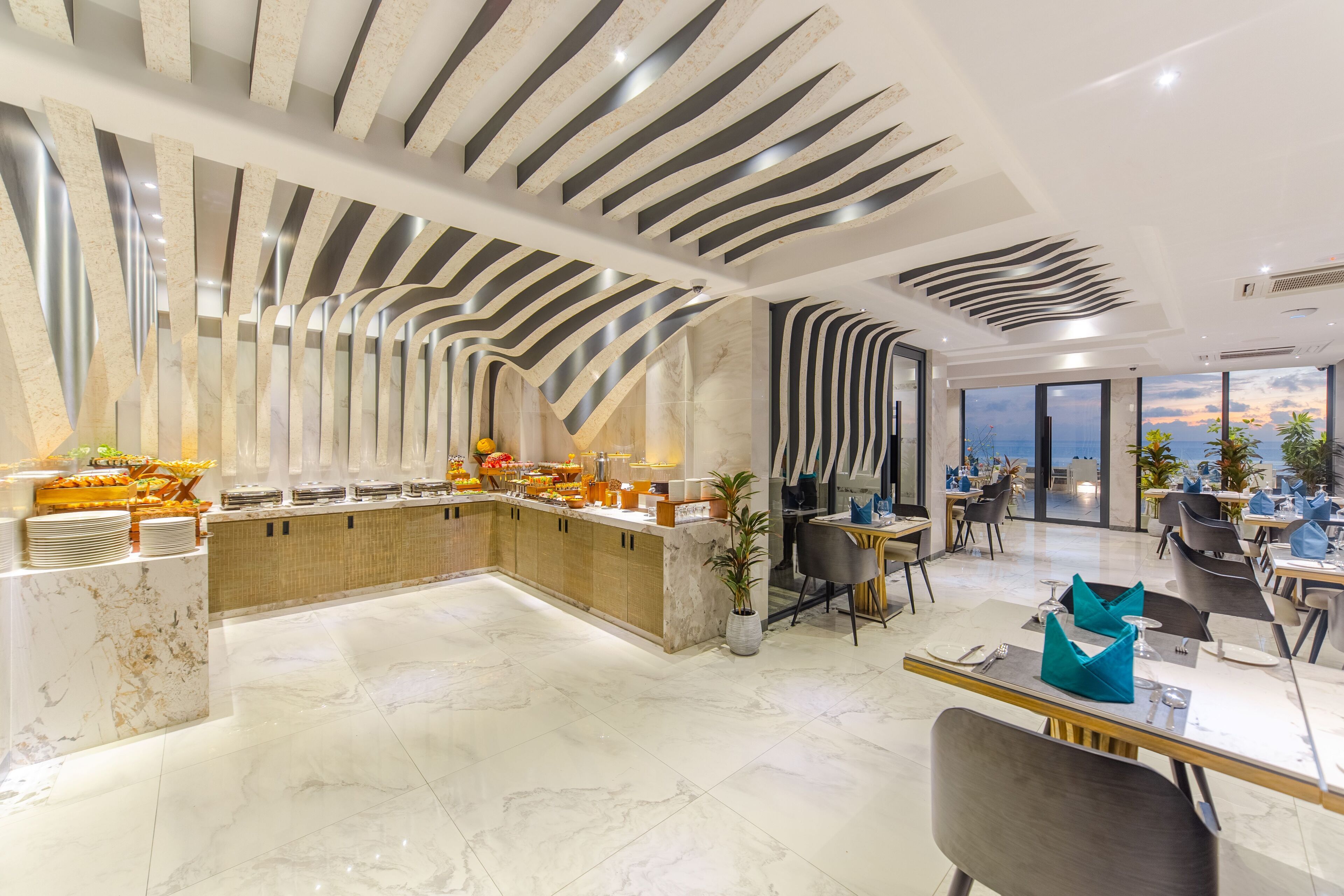 A modern hotel lobby with a marble floor, a central bar area, and a dining section with tables and chairs.