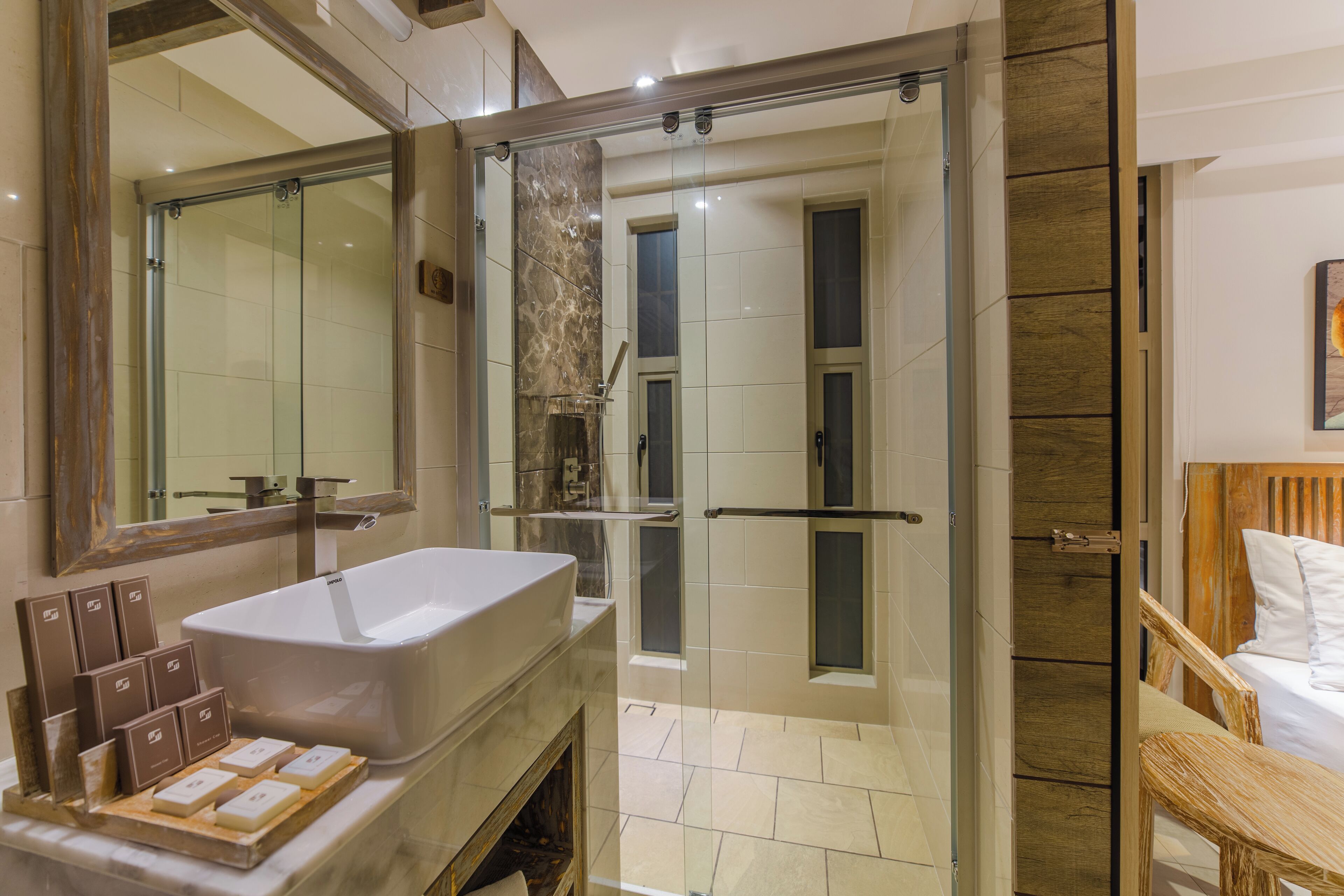 A modern bathroom with a large bathtub, a glass-enclosed shower, and a wooden vanity.