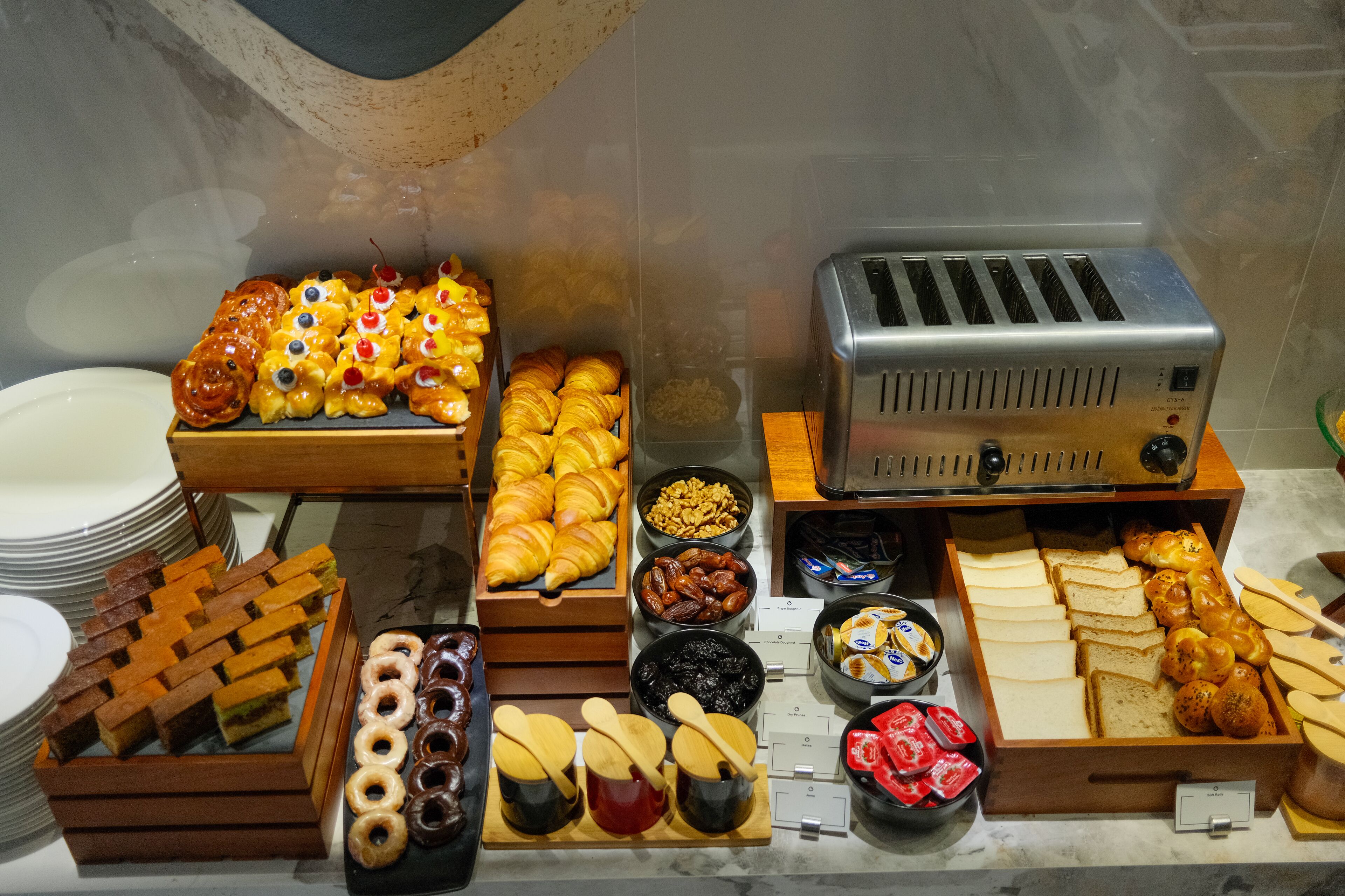 Un buffet de petit-déjeuner proposant une variété de viennoiseries, de pains et d’accompagnements.