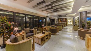Eine geräumige Lobby mit moderner Möblierung, großen Fenstern und einer gut beleuchteten Decke.