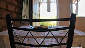 A chair with a woven backrest and a table with a lace tablecloth. - Farinha de Pau - Eco Rural Project (Tarrafal de Sao Nicolau)