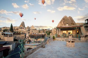 Un pueblo histórico con edificios de piedra y una formación rocosa destacada.
