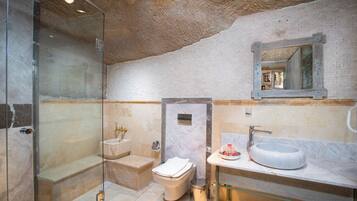 Ein modernes Badezimmer mit Duschkabine aus Glas, Marmorwaschbecken und weißer Toilette.