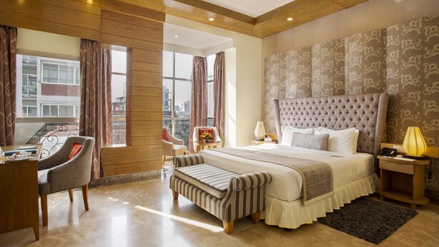 Una habitación de hotel moderna con una cama grande, un escritorio y una silla.