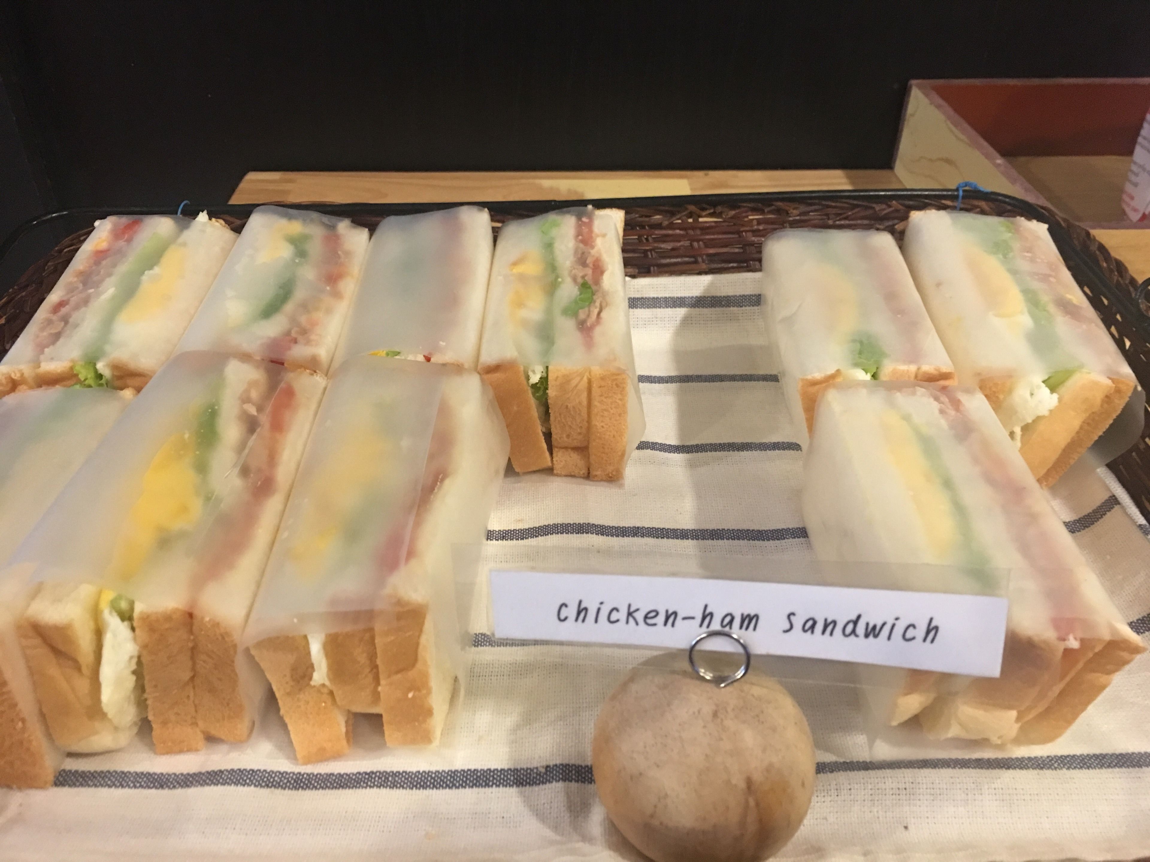 Una bandeja de sándwiches de pollo y jamón con una etiqueta.