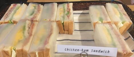 Una bandeja de sándwiches de pollo y jamón con una etiqueta.