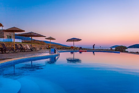 Una piscina al aire libre de temporada, sombrillas