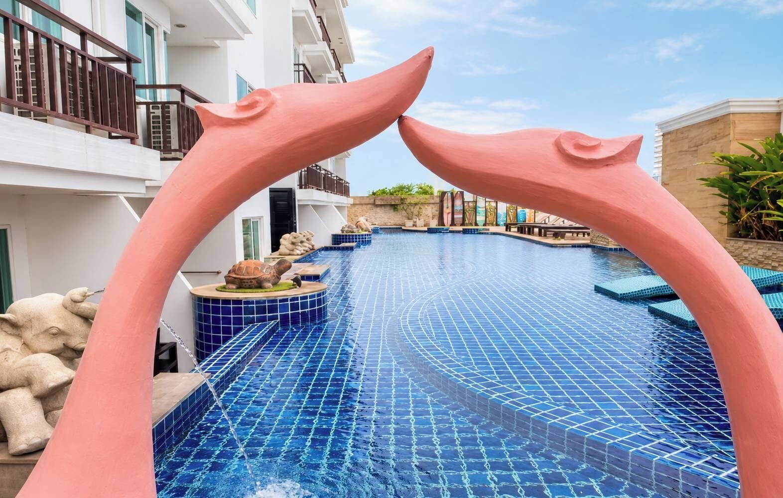 Uma piscina com um design de arco único, uma estátua de tartaruga e uma escultura de pedra.