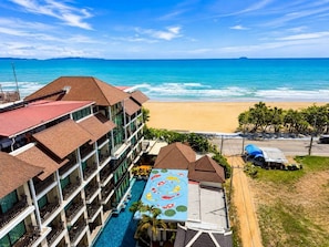 A hotel with a swimming pool, a beach view, and a colorful mural.