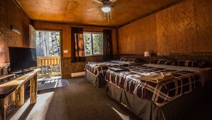 A cabin with three beds, a TV, and a ceiling fan. - Mountain View Cabins (Golden)