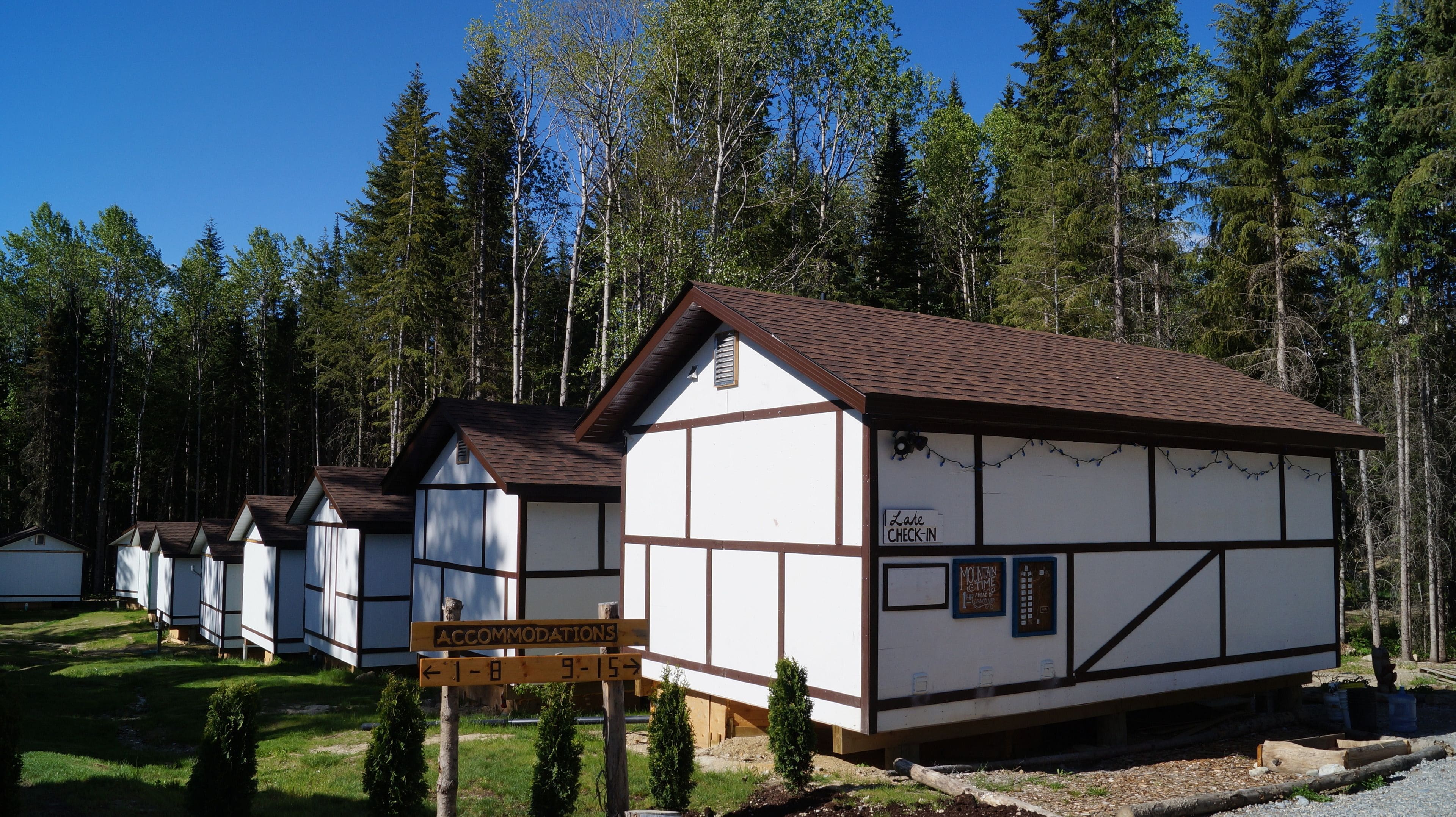 A row of traditional timber-framed buildings with a sign indicating accommodations.