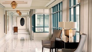 Un hall d’hôtel moderne, doté d’un sol ciré, de grandes fenêtres et de mobilier contemporain.