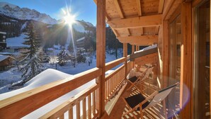 A wooden balcony with a view of snow-covered mountains and a clear sky. - Hôtel Les Escondus (Vars)
