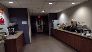 A kitchen area with a long counter, equipped with various appliances and food items. - Quality Inn & Suites Caldwell I-77 (Caldwell)