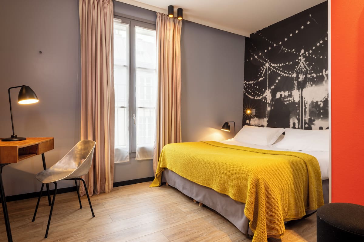 A modern bedroom with a bed, a desk, and a chair.