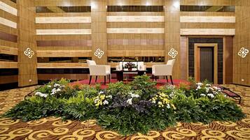 A conference room with a round table, white chairs, and a red carpet.
