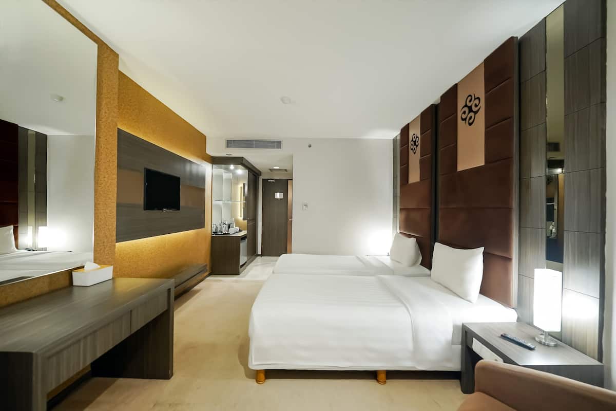 Une chambre d’hôtel moderne équipée d’un grand lit, d’une table de chevet, d’un bureau et d’une télévision.